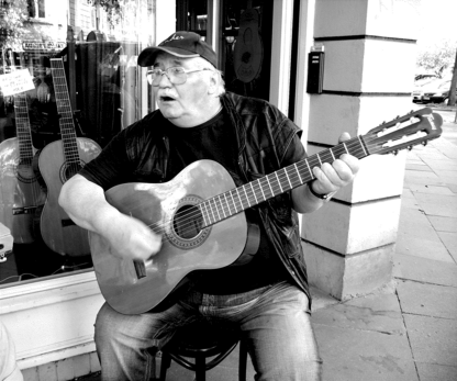 Locomotive driver playing guitar, in front of Wichmanns guitar shop in Hamburg.